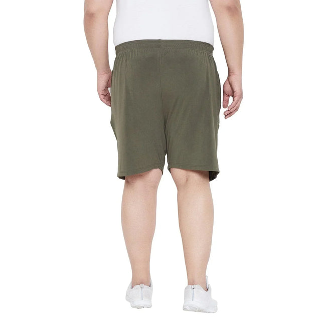 Back view of a man wearing olive green plus size shorts and a white t-shirt