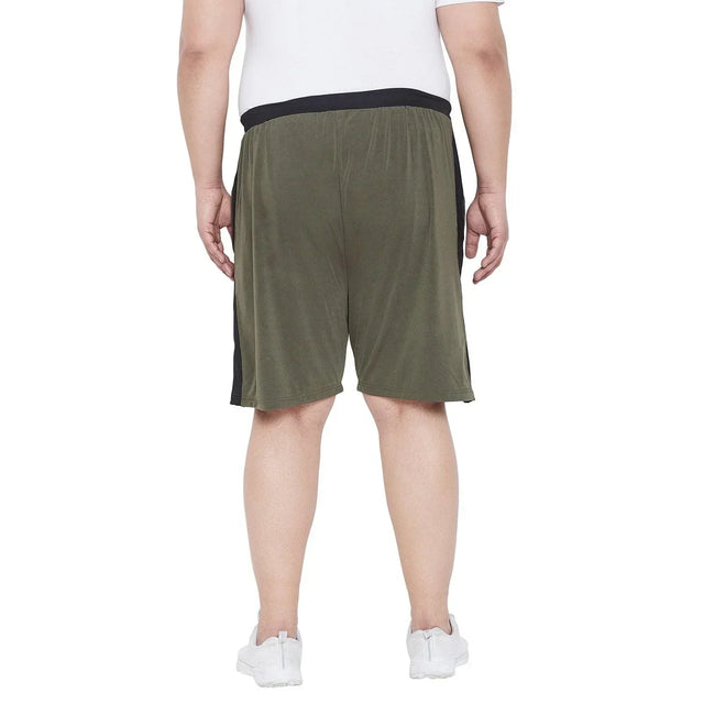 Back view of a plus size man wearing olive green shorts with black waistband and white sneakers