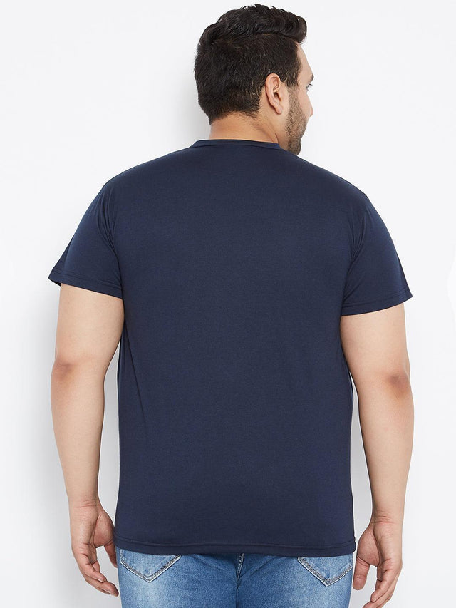 Back view of a plus size man wearing a navy blue t-shirt and blue jeans