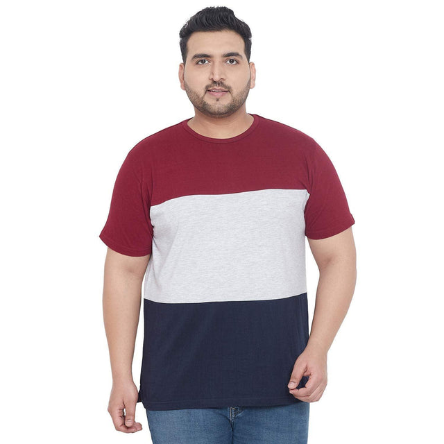 Plus size man wearing a colorblock t-shirt in red, grey, and navy with jeans