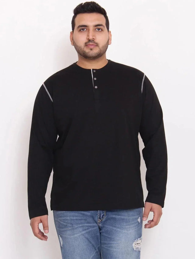 Plus size man wearing black long sleeve henley t-shirt and blue distressed jeans
