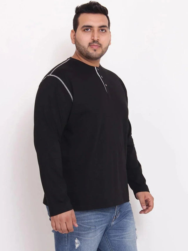 Plus size man wearing black long sleeve henley t-shirt and blue ripped jeans