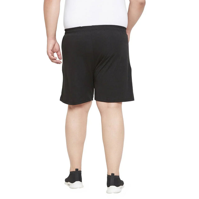Back view of plus size man wearing black shorts and white t-shirt standing on white background
