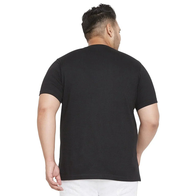 Back view of a man wearing a plain black plus size t-shirt and white pants